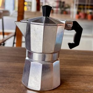 Cafetera moka de aluminio sobre una mesa de madera
