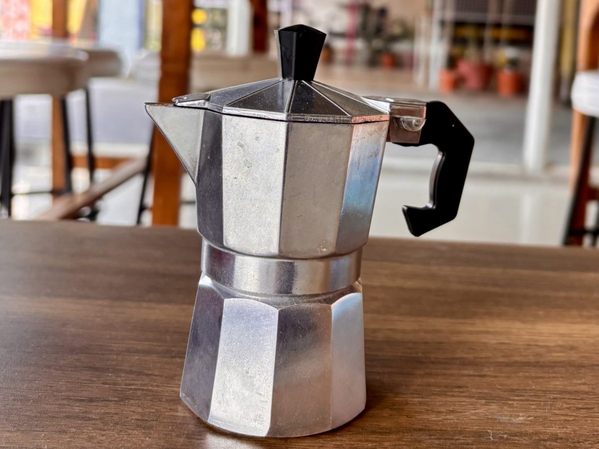 Cafetera moka de aluminio sobre una mesa de madera